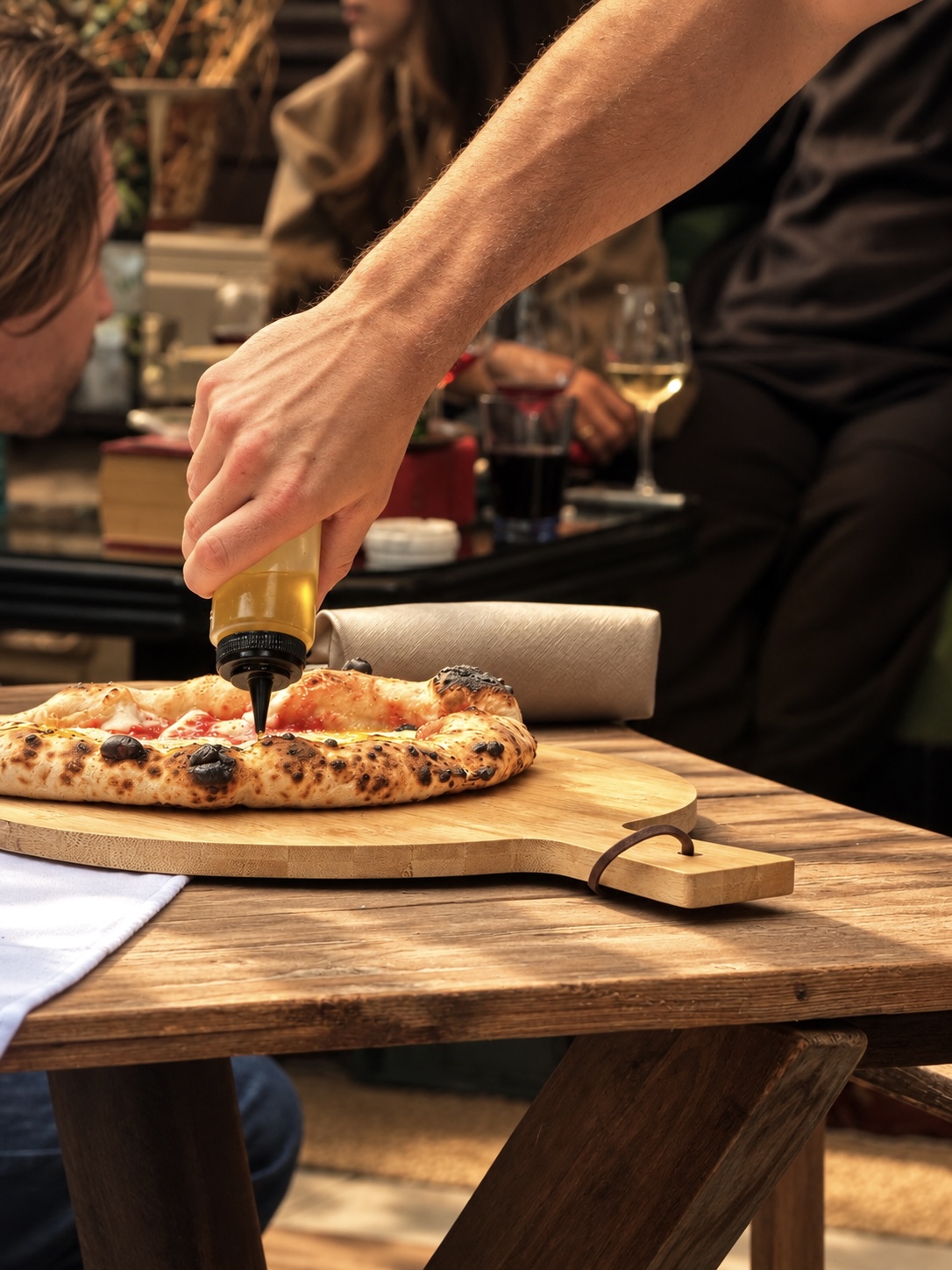 Olívaolaj csorgatása a frissen sült pizzára