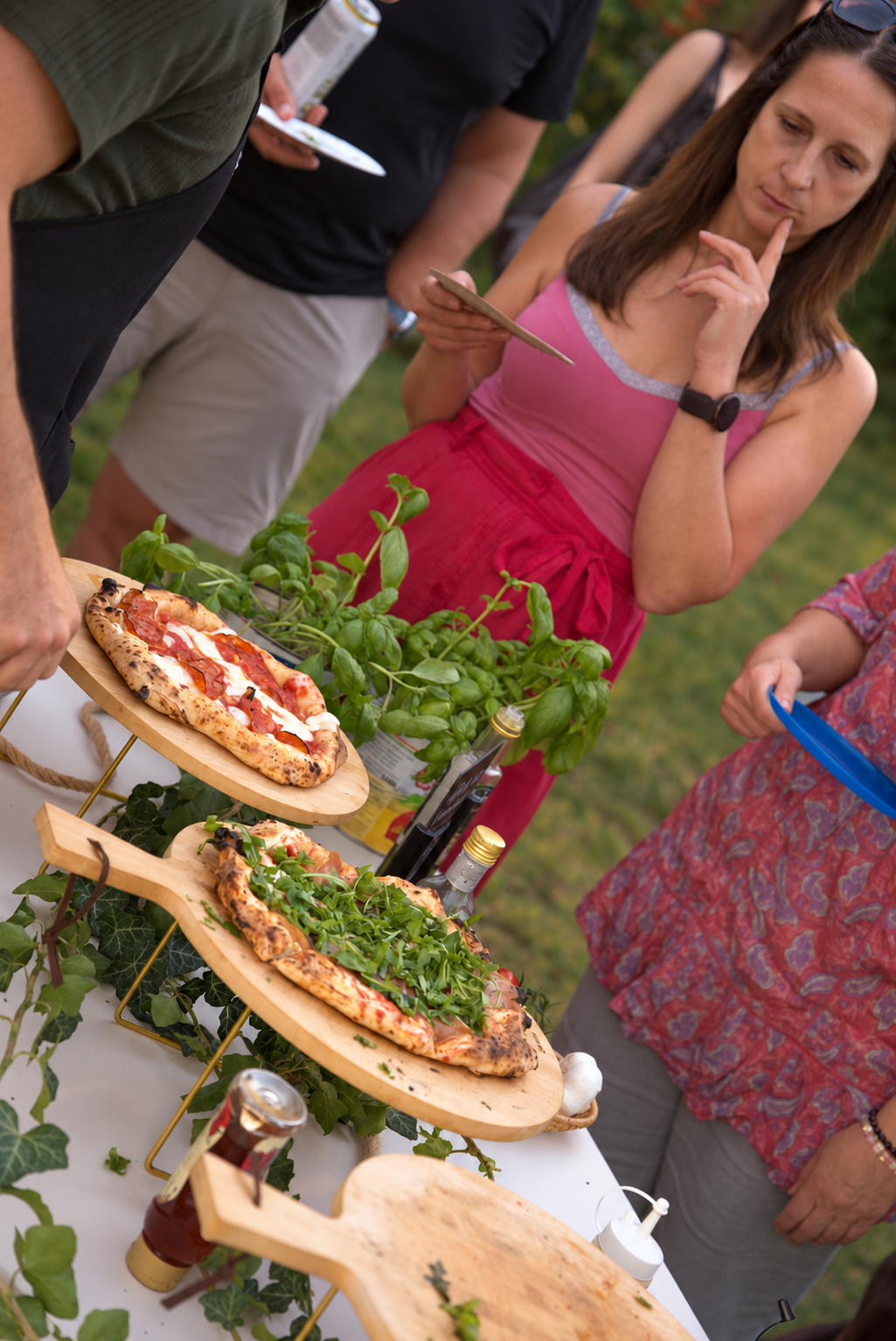 Vendégek pizzát választanak a kerti rendezvényen